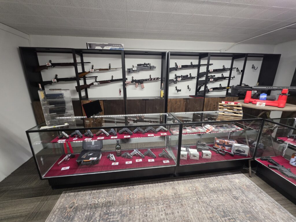 Firearms displayed on wall racks and in glass cases