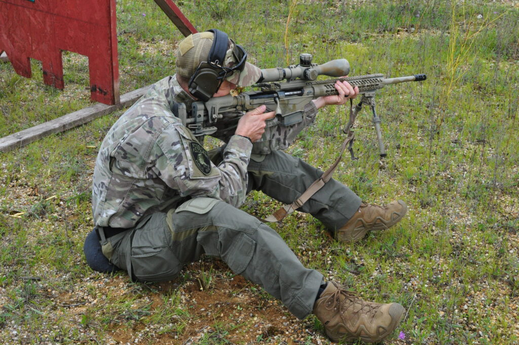 Participant looking through a rifle scope at an outdoor range