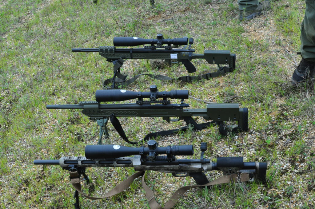 Scoped rifles resting on grass
