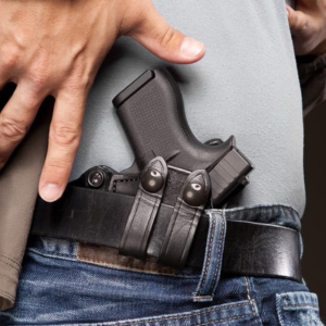 Hand resting on a holstered handgun
